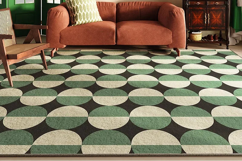 Living room with a patterned green and black carpet, brown sofa, and wooden chair.
